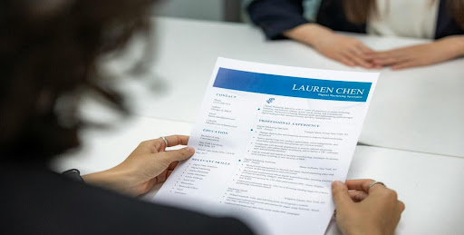 Recruiter reviewing a resume during an interview, symbolizing gamified job assessments and placement innovation in modern hiring practices.